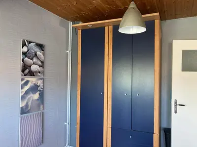 a room with blue cabinets and a light fixture at 'Onder-dak' 2-persoons appartement in Zandvoort