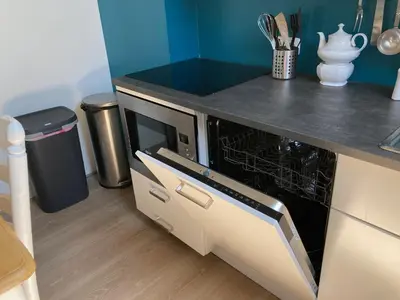 a kitchen with a microwave oven in a counter top at 'Onder-dak' 2-persoons appartement in Zandvoort