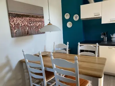 a dining room with a wooden table and chairs at 'Onder-dak' 2-persoons appartement in Zandvoort