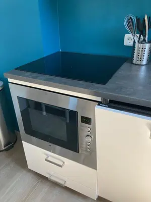 a microwave oven in a kitchen with a counter top at 'Onder-dak' 2-persoons appartement in Zandvoort