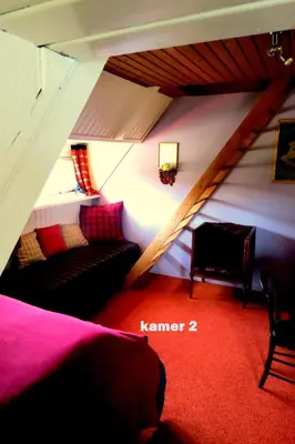 a attic room with a bed and a couch at Villa Zomerdijk in Velsen-Zuid