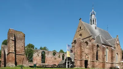 a large brick church with a tower and a steeple at Meerpaal 43 Bergen in Bergen