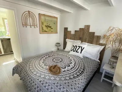 a bedroom with a bed with a comforter on it at Meerpaal 43 Bergen in Bergen