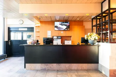 a bar in a restaurant with a counter at Bastion Hotel Schiphol Hoofddorp in Hoofddorp
