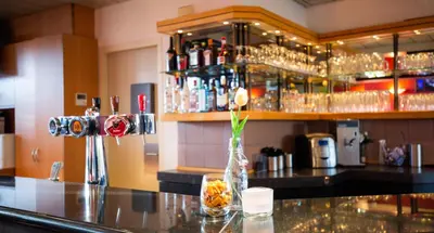a bar with a vase with a flower on a counter at Bastion Hotel Schiphol Hoofddorp in Hoofddorp