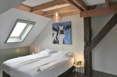 a bedroom with a large bed and a window at Vakantiehuis Overleek in Monnickendam