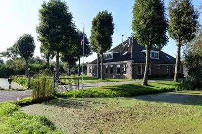 a house with a flag in front of it at Vakantiehuis Overleek in Monnickendam