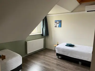 a bedroom with two beds and a window at Vakantiehuis Overleek in Monnickendam