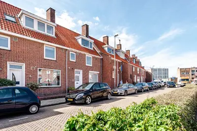 a row of cars parked next to a brick building at Albatros aan Zee - Studio in Zandvoort