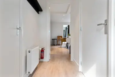 a hallway with white walls and a hard wood floor at Amsterdam Dunes Holiday Home in Zandvoort