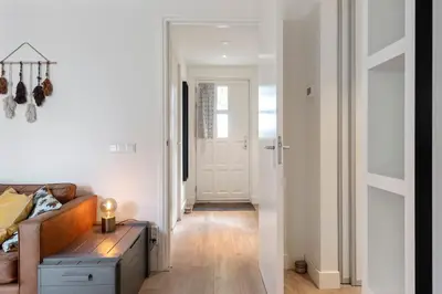 a living room with a couch and a door at Amsterdam Dunes Holiday Home in Zandvoort