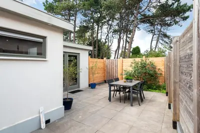 a patio with a table and chairs next to a fence at Amsterdam Dunes Holiday Home in Zandvoort