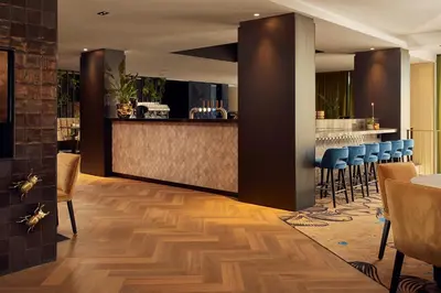 a bar in a restaurant with blue stools at Van der Valk Hotel Leusden - Amersfoort in Leusden
