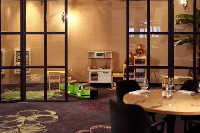 a room with tables and chairs and a room with windows at Van der Valk Hotel Leusden - Amersfoort in Leusden
