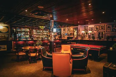 a bar with a pool table and some chairs at Two Brothers Noordwijk Beach in Noordwijk aan Zee
