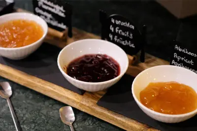 a tray with three bowls of jam and sauce at Two Brothers Noordwijk Beach in Noordwijk aan Zee