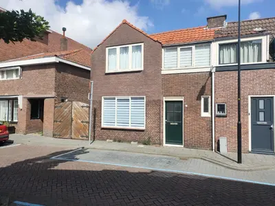 a brick house with a green door on a street at House with garden in the center close to the sea and Amsterdam in Beverwijk