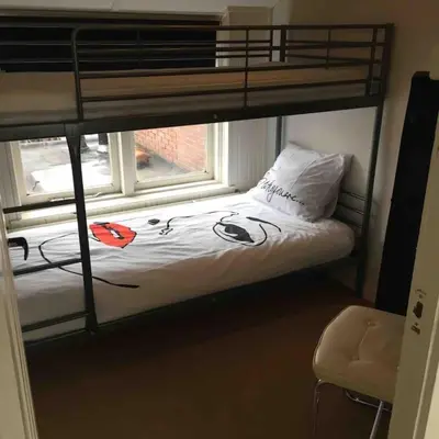 a bedroom with a bunk bed with a window at House with garden in the center close to the sea and Amsterdam in Beverwijk