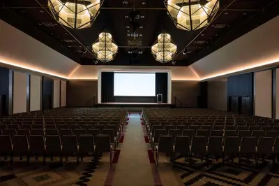 an empty cinema room with a screen and chairs at Anantara Grand Hotel Krasnapolsky Amsterdam in Amsterdam