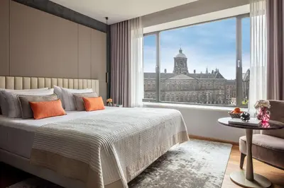 a bedroom with a bed and a large window at Anantara Grand Hotel Krasnapolsky Amsterdam in Amsterdam