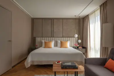 a bedroom with a large bed and a couch at Anantara Grand Hotel Krasnapolsky Amsterdam in Amsterdam