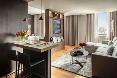 a kitchen and living room with a couch and a table at Anantara Grand Hotel Krasnapolsky Amsterdam in Amsterdam