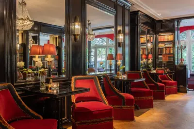 a bar with red chairs and tables in a library at Apollofirst Boutique Hotel in Amsterdam