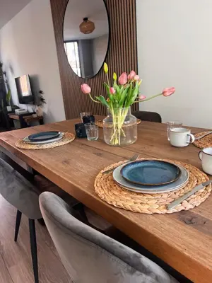 a wooden table with blue plates and flowers on it at Casa Xabia in Zaandam