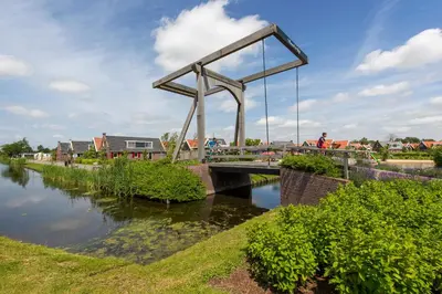 a bridge over a river with a person on it at De Beemster | Holiday park near Amsterdam in De Rijp