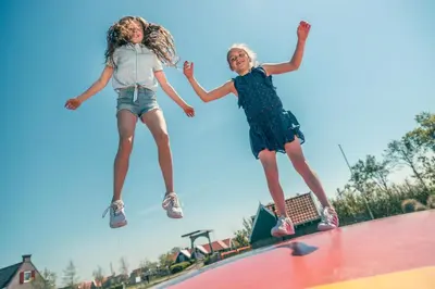 two girls jumping on top of a trampoline at De Beemster | Holiday park near Amsterdam in De Rijp