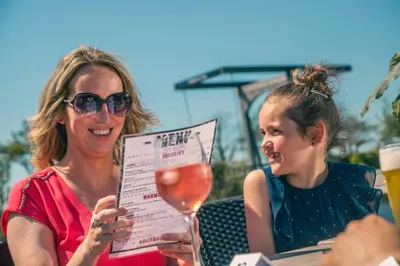 two women sitting at a table with a glass of wine at De Beemster | Holiday park near Amsterdam in De Rijp