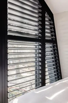 a bedroom with a window with aluminium blinds at Lovely private cottage near Amsterdam in Broek in Waterland