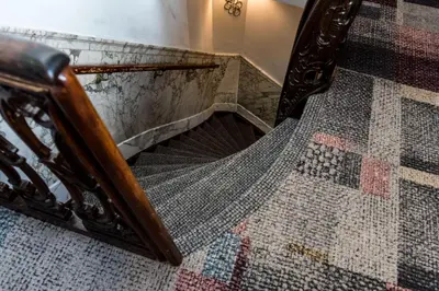 a staircase with a mirror and a mosaic floor at Hotel Amstelzicht in Amsterdam