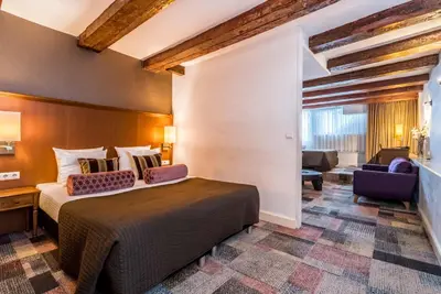 a hotel room with a bed and a chair at Hotel Amstelzicht in Amsterdam
