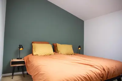 a bedroom with a large bed with two yellow pillows at Eco lodge Duin- unieke locatie -strand, duin en nabij cultuursteden in Castricum