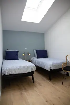 two beds with blue pillows in a room at Eco lodge Duin- unieke locatie -strand, duin en nabij cultuursteden in Castricum