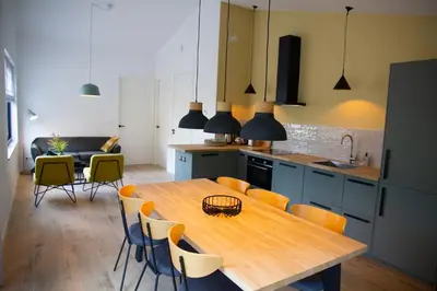 a kitchen with a wooden table and chairs at Eco lodge Duin- unieke locatie -strand, duin en nabij cultuursteden in Castricum