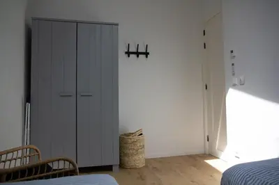a bedroom with a gray cabinet and a bed at Eco lodge Duin- unieke locatie -strand, duin en nabij cultuursteden in Castricum