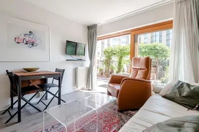 a living room with a couch and a table and a desk at Apartment Garden & Bed in Zandvoort