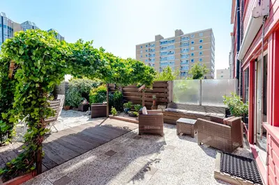 a patio with chairs and a bench on a building at Apartment Garden & Bed in Zandvoort