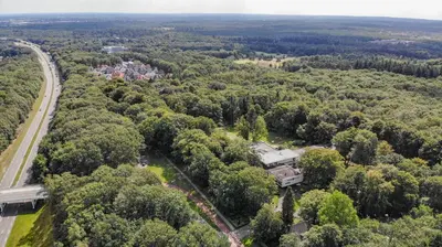 an aerial view of a forest with a house in the middle at Fletcher Hotel Restaurant Amersfoort in Amersfoort