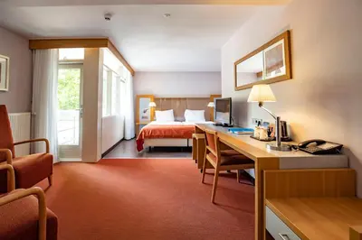 a hotel room with a bed and a desk with a computer at Fletcher Hotel Restaurant Amersfoort in Amersfoort