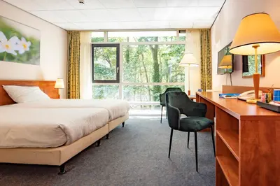 a hotel room with a bed and a desk and a desk at Fletcher Hotel Restaurant Amersfoort in Amersfoort