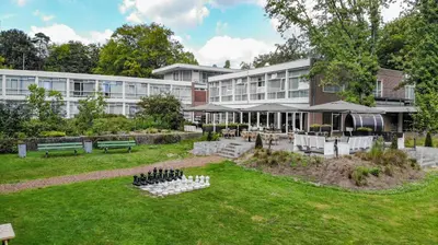 a building with a park in front of it at Fletcher Hotel Restaurant Amersfoort in Amersfoort