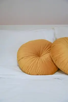 two orange pillows sitting on a bed at Riverbridge Suite - Historic Center Canal District in Amsterdam