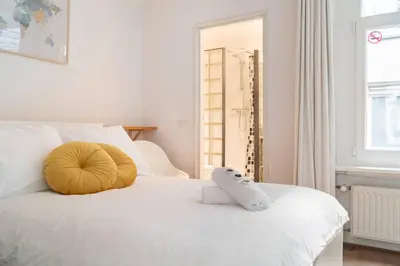 a white bed with a stuffed animal on top of it at Riverbridge Suite - Historic Center Canal District in Amsterdam