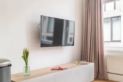 a flat screen tv hanging on a white wall at Riverbridge Suite - Historic Center Canal District in Amsterdam