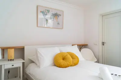 a bed with a yellow pillow on top of it at Riverbridge Suite - Historic Center Canal District in Amsterdam