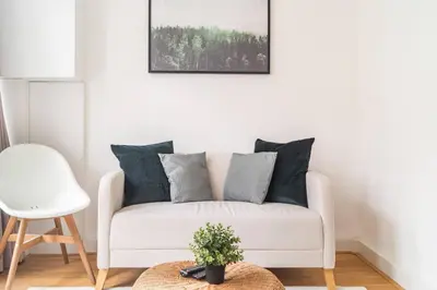 a white couch in a living room with a table at Riverbridge Suite - Historic Center Canal District in Amsterdam