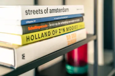 a stack of books sitting on a shelf at Elegant Boutique Apartment 45m2 w Amazing Views in Amsterdam